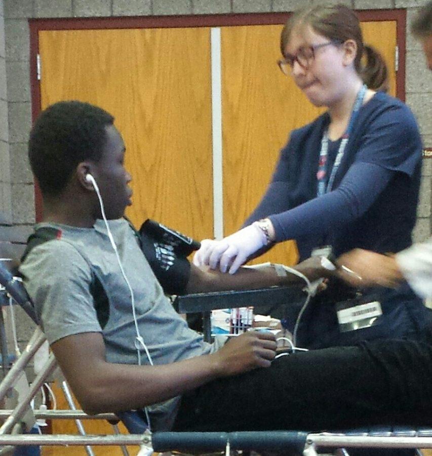 UDII+Kukiele+Kimonawoko+getting+assisted+by+a+nurse%2C+while+she+draws+his+blood.