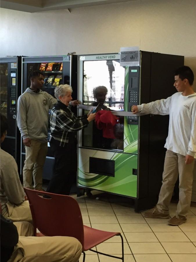 Sister+Linda+stands+with+freshman+to+celebrate+the+new+vending+machine.+Eighty+percent+of+the+proceeds+will+go+to+the+food+pantry.