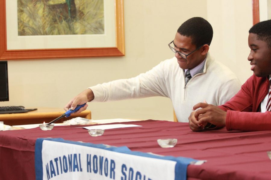 Jose Garcia, president of the National Honor Society lights the candle.