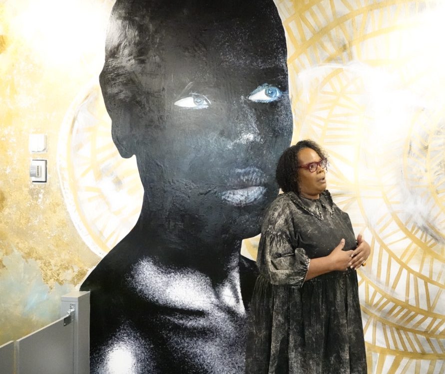 Armisey Smith in front one of her murals.